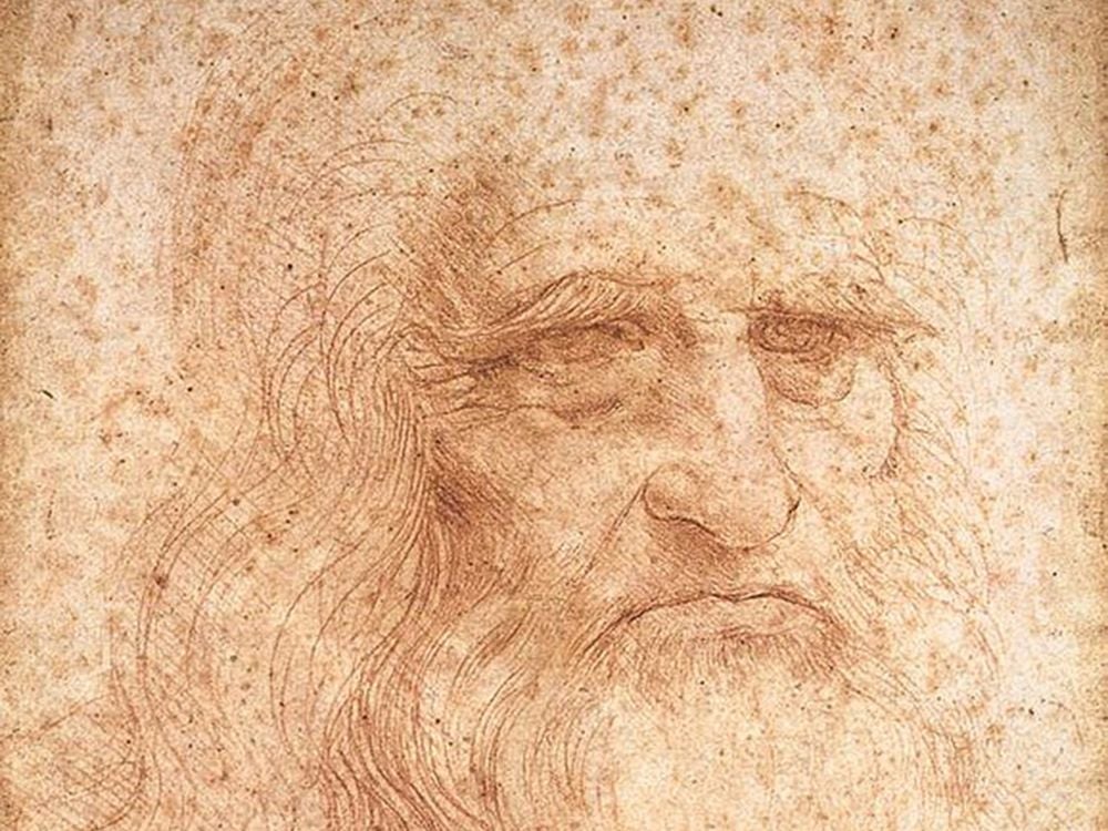 A portrait of an elderly man's face and long hair and beard, rendered in fine red chalk lines on a paper spotted with age