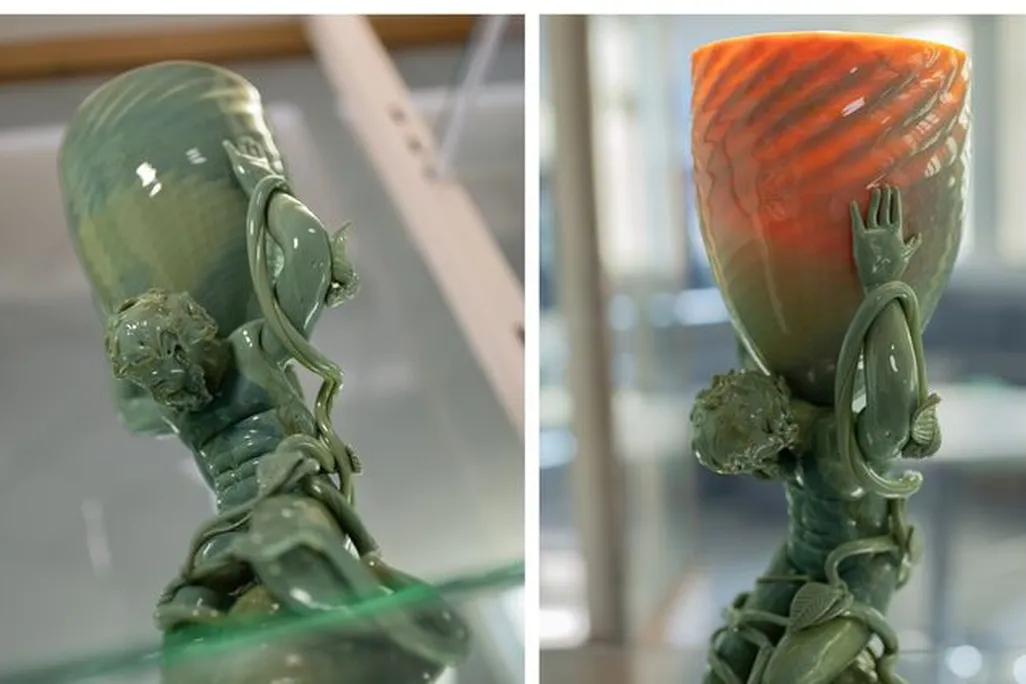 Side-by-side image of a sculpture that appears green on the left side and orangeish red on the right side