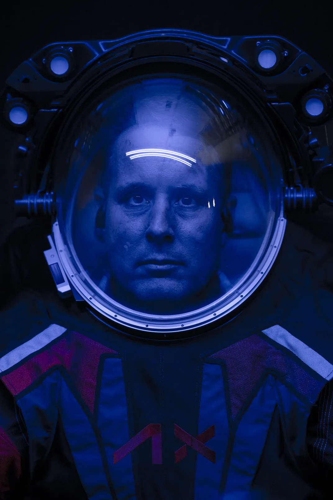 Close-up shot of man's face inside spacesuit helmet