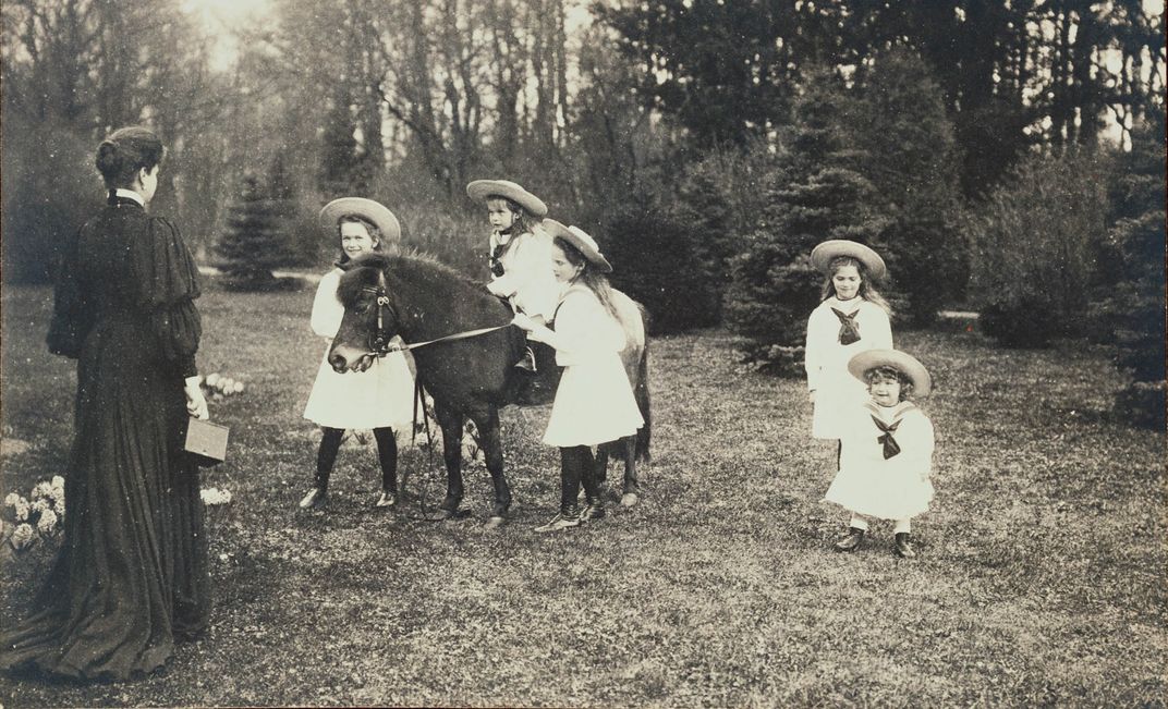 Alexandra (standing, left) holds a camera as she speaks to her children (left to right), Olga, Anastasia, Tatiana, Maria and Alexei.