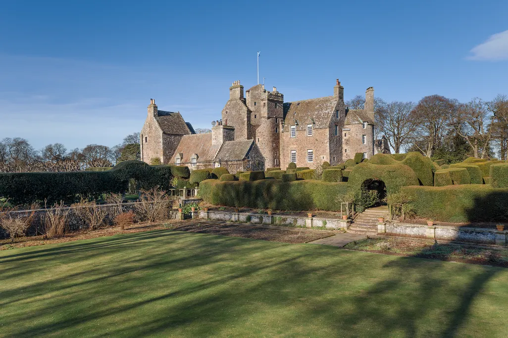 Large Gray stone castle overlooking vast green landscape