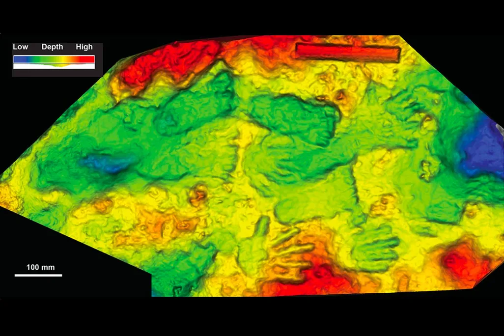 Photo of hand and footprints on a tavertine boulder