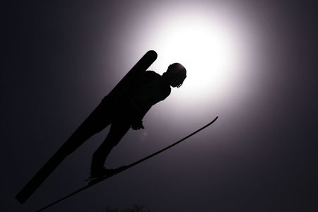 A ski jumper flashes a V.