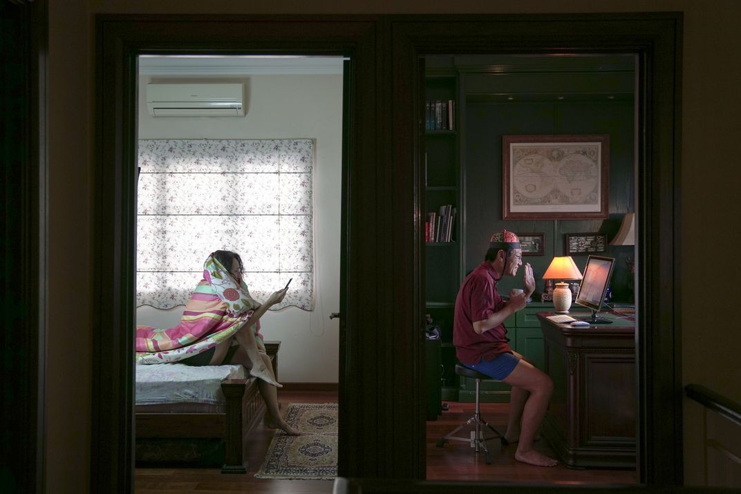 Photograph of two people celebrating Lunar New Year on a phone and a computer