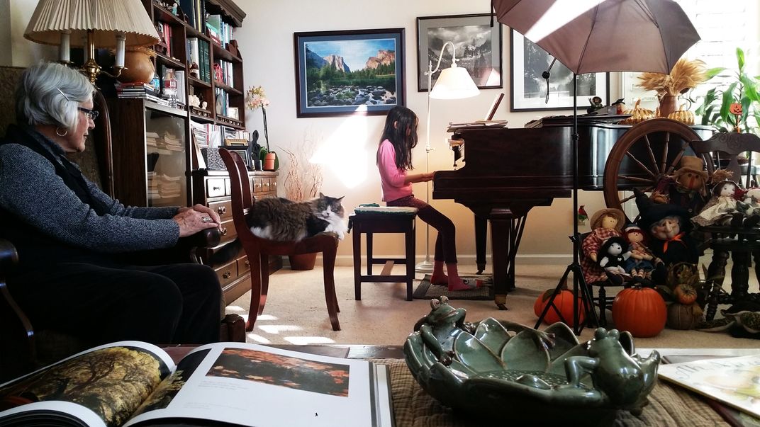 5 - Piano instructor Mrs. McBee sits comfortably as she assesses how a young student is progressing with her lessons. Cookie, the cat, may have some tips, too.