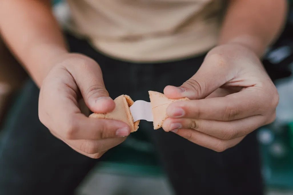 Close-up shot of person opening a fortune cookie