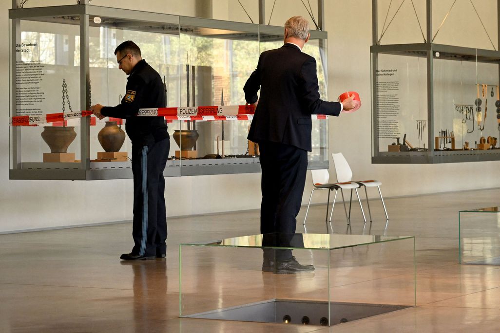 Policemen fix a barrier tape on November 23, 2022 in the exhibition room of the Celtic and Roman museum in Manching, southern Germany, where a hoard of Celtic coins was on display before the treasure was stolen.