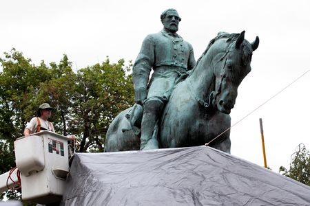 In Charlottesville, Virginia, city workers drape a tarp over the statue of Confederate General Robert E. Lee in Emancipation park to symbolize the city's mourning for Heather Heyer, killed while protesting a white nationalist rally in August. 