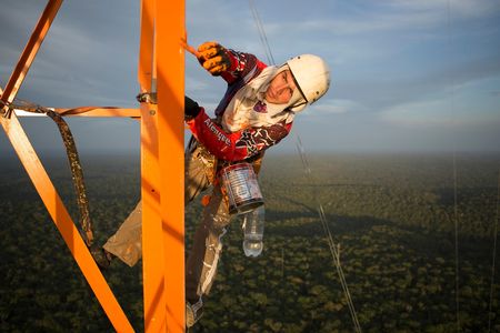 A worker puts finishing paint touches on the Amazon Tall Tower Observatory in January