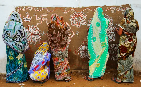 women making traditional art on the wall in pushkar. thumbnail