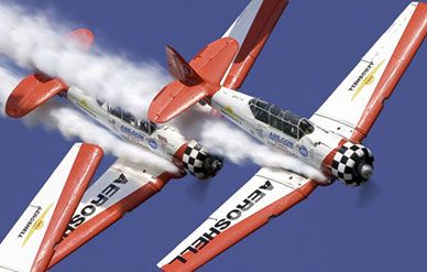 "The AeroShell Aerobatic Team is an act not to miss. This formation team flies the venerable AT-6G Texan and is a perennial favorite on the airshow circuit. With skill, grace and coordination this is precision formation flying at its best. And who does't like watching big honking radial engines, belching clouds of smoke, whip the sky into submission? Photographically, the AeroShell Team fills your viewfinder with a little bit of history, a lot of energy and loads of color against a azure sky. Now go eat some smoke and take some pictures."