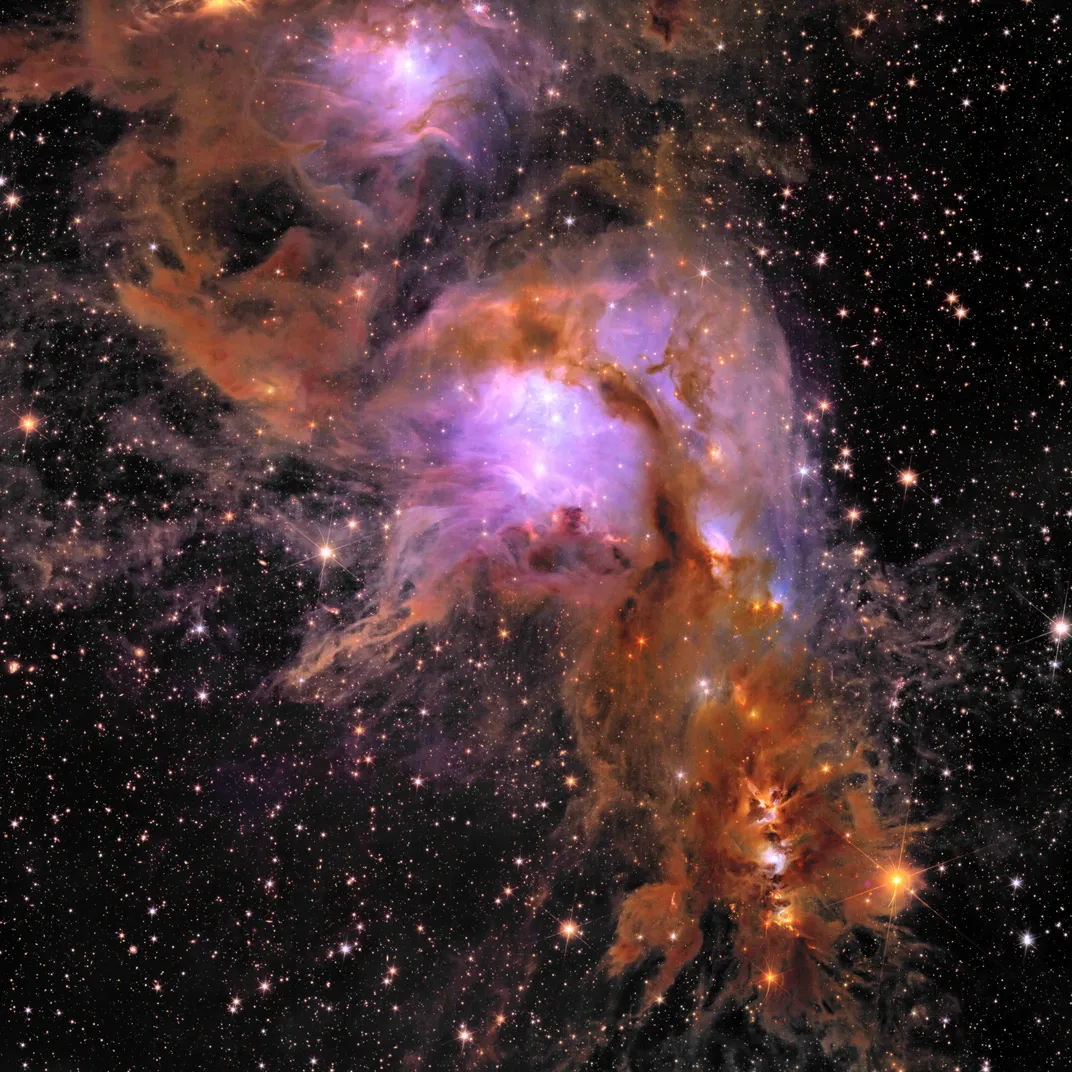a purple and orange cloud of gas with bright dots of stars all over