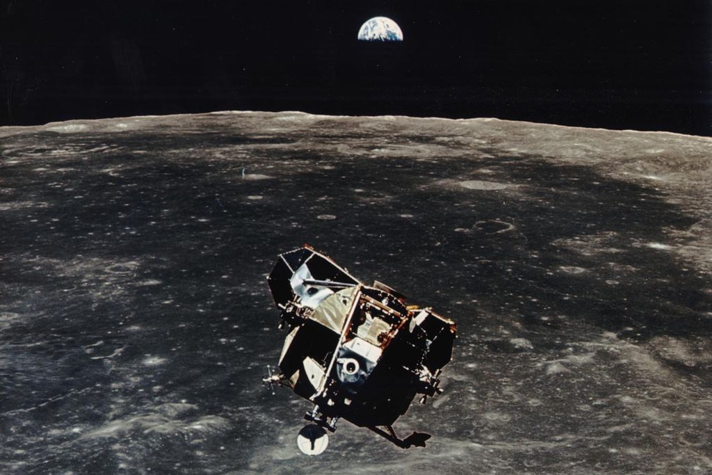 Apollo 11 ascent stage aloft above Earth with the moon rising in the distance