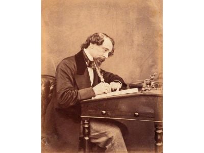 Charles Dickens, seen at his desk in 1858
