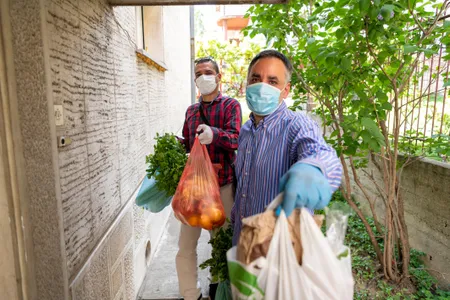 "Engaged philanthropy is vital to democracy," writes Smithsonian scholar Amanda B. Moniz, who studies the history of giving in America. Above: charity workers bring groceries to those isolating with symptoms of Covid-19. 