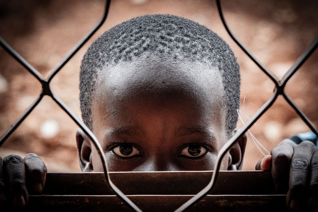 African boy behind fence | Smithsonian Photo Contest | Smithsonian Magazine