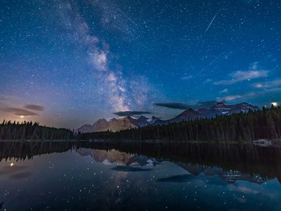 According to Getty: Photographed in July 2018, this view looking south at Herbert Lake, Banff National Park, Alberta, shows the Milky Way over Mount Temple and the peaks of the Continental Divide. To the left in the clouds, Mars is hiding. Then Jupiter flanks the Milky Way on the right, while Saturn sits within the Milky Way.