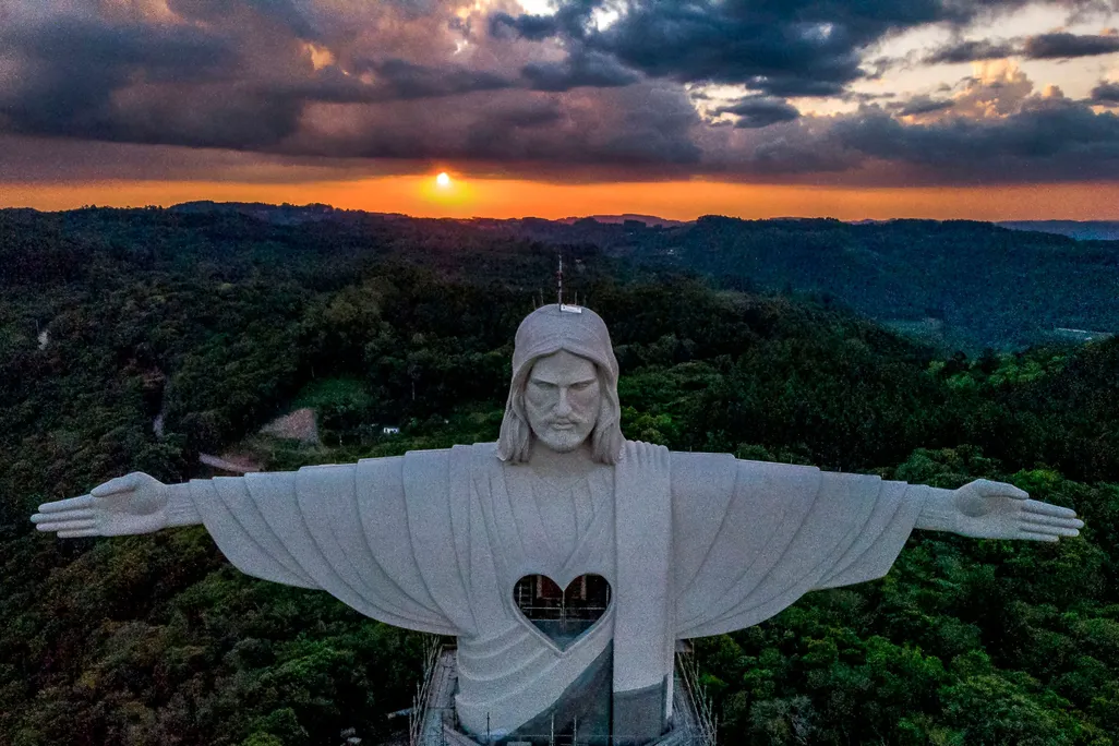 Image of the top half of "Christ the Protector" with the sun setting in the background