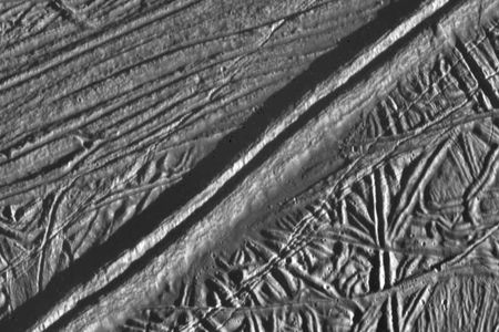 Europa’s surface as seen by NASA’s Galileo probe, with a prominent double-ridge system running from the lower left to the upper right. The feature could function similarly to a mid-oceanic ridge on Earth.