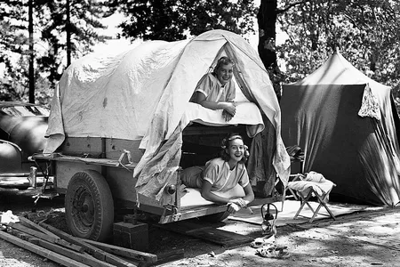 Monon and Ottily Bayer, the daughters of Mr. and Mrs. Otto Bayer of Costamesa, California, pose in a small, "bunk bed" trailer at their campground in the Shasta National Forest. California, August 1953.