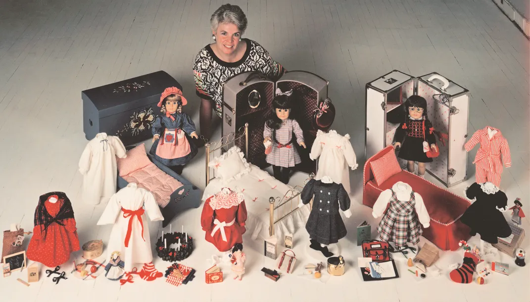 American Girl's founder, Pleasant Rowland, poses alongside the three original dolls: Kirsten, Samantha and Molly.