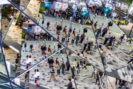 People crossing a Tokyo street are caught in a mirror. As the country's foreign population grows, racism is thought to be on the rise.