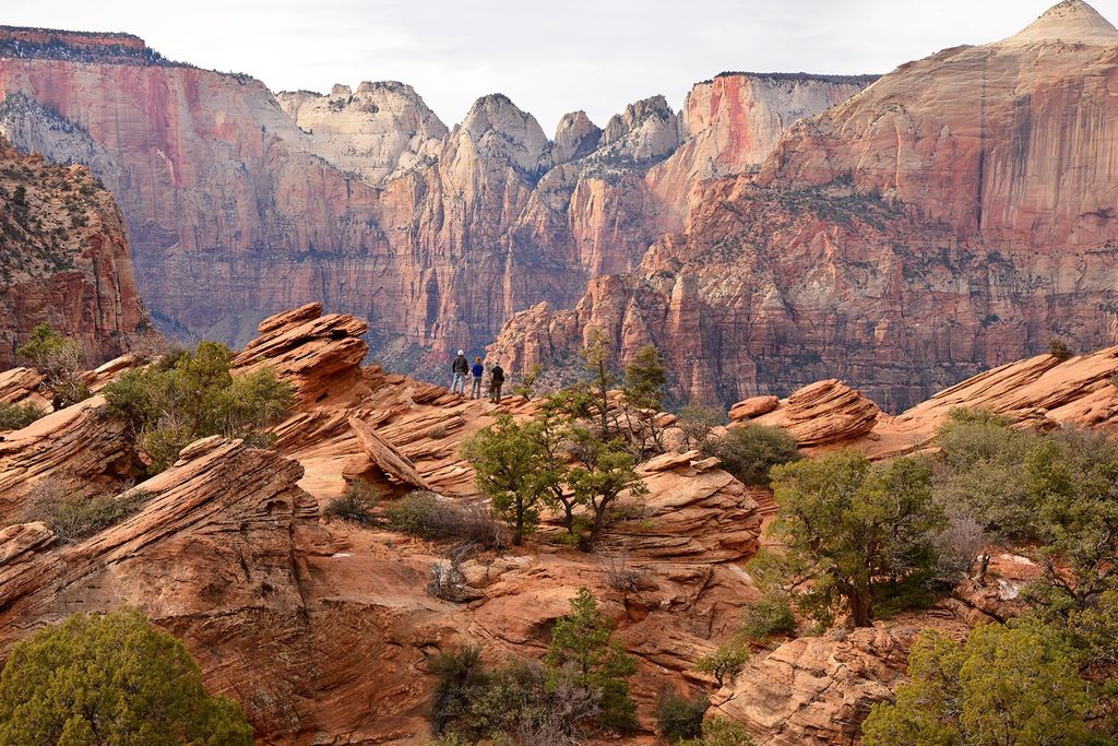Hikers against reddish rock backdrop