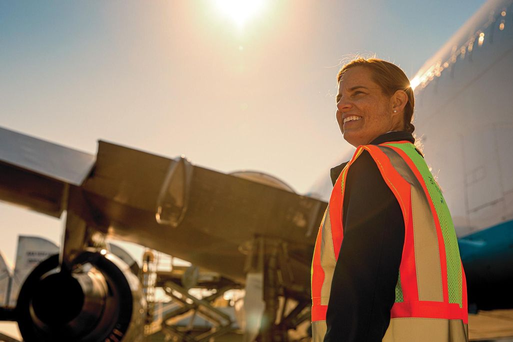 Sarag Rhoads in from of aircraft wearing vest