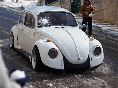 Teenagers in the West Bank hit a Volkswagen Beetle with a snowball.