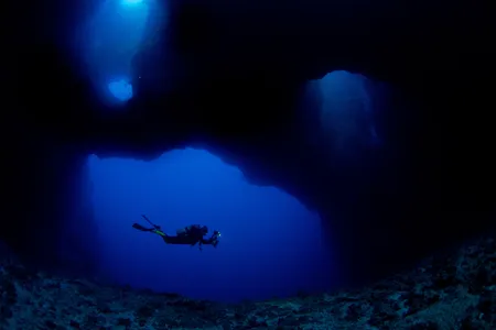 A scuba diver swims in the coral reefs of Palau. Beneath the depths that humans can dive, natural wonder and a better understanding of our planet awaits. 