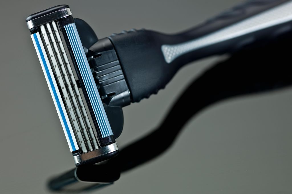 A standard three-blade razor with black and gray handle