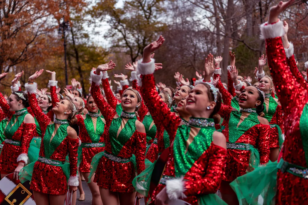 5 - Performers in sequined, Christmas red-and-green ensembles wave to those observing the Macy’s Thanksgiving Day Parade from above.