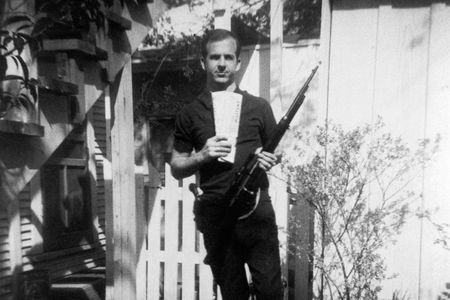 Lee Harvey Oswald stands in his backyard with Marxist newspapers and a rifle. This photo has been looked on with suspicion ever since Oswald called it a fake after John F. Kennedy's assassination in 1963.