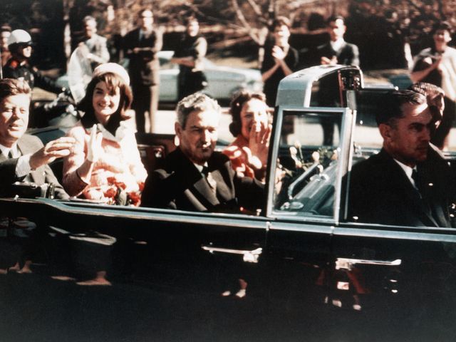 John F. Kennedy and Jackie Kennedy ride the presidential limousine through the streets of Dallas, Texas, on November 22, 1963. Texas Governor John B. Connally Jr. is seated in front of them.