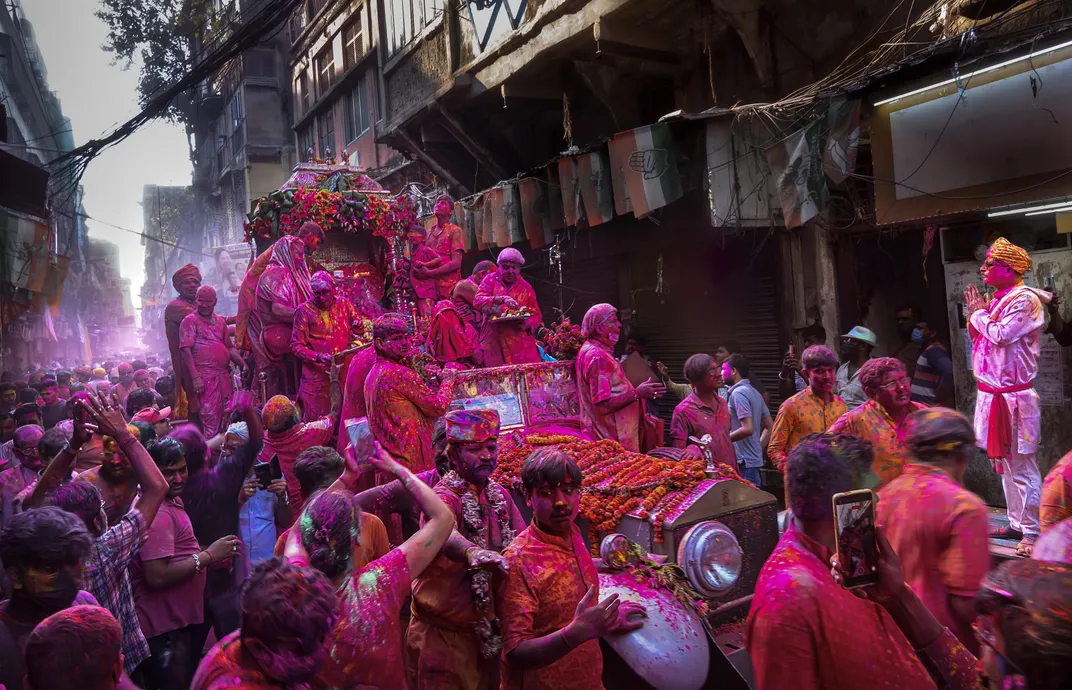 people in the streets covered in pink powder during Holi Festival
