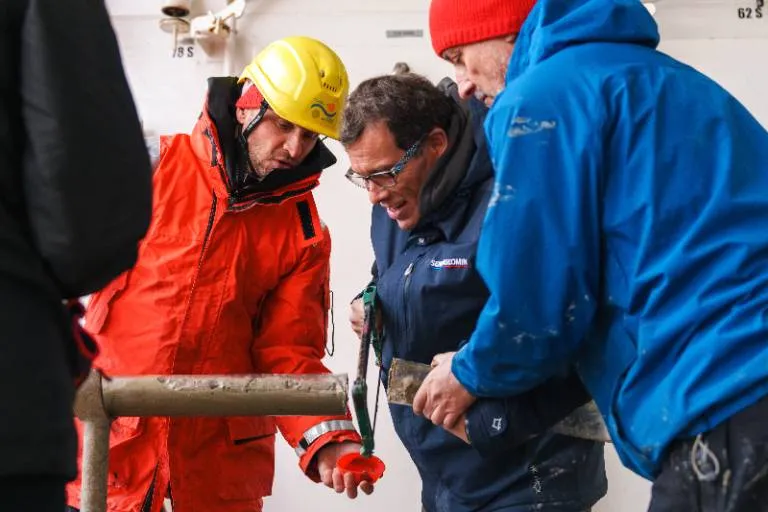 Researchers looking at a sediment core