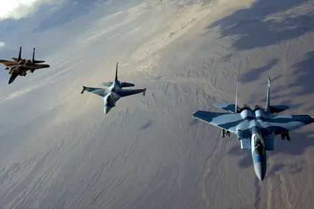 Tough-guy F-15s flank a grown-up F-16 over Nellis Air Force Base, Nevada, in 2007. 