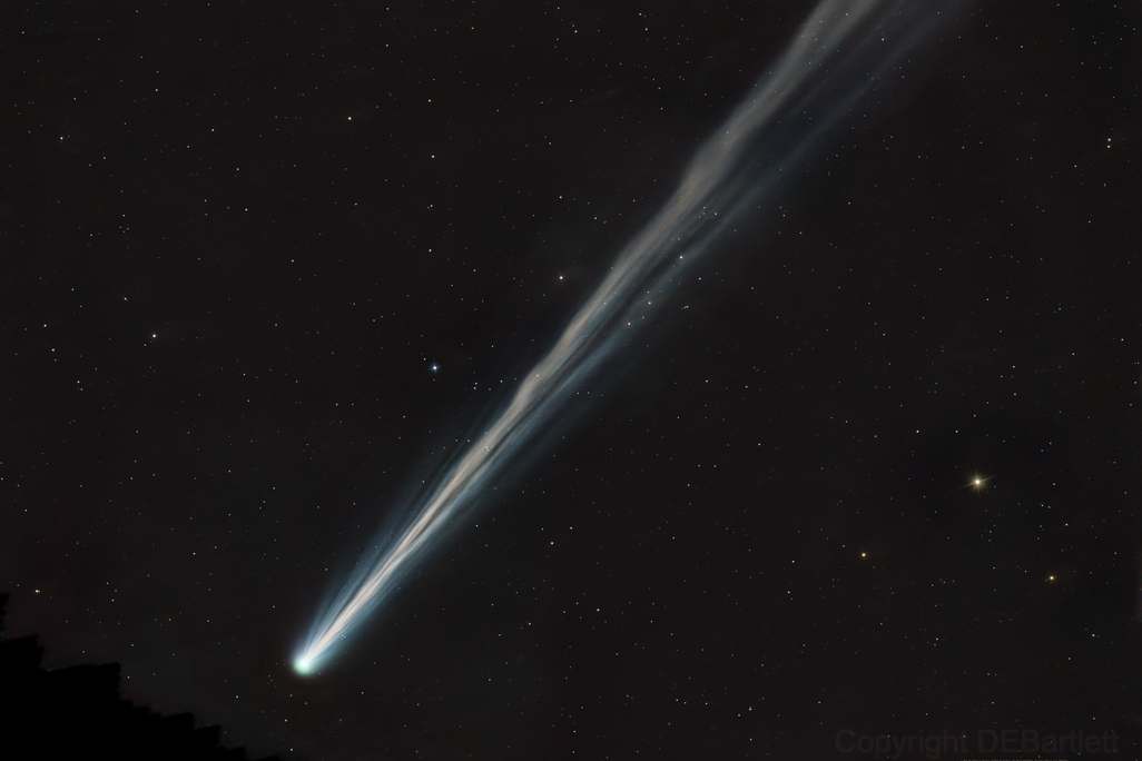 A white comet streaks across dark space