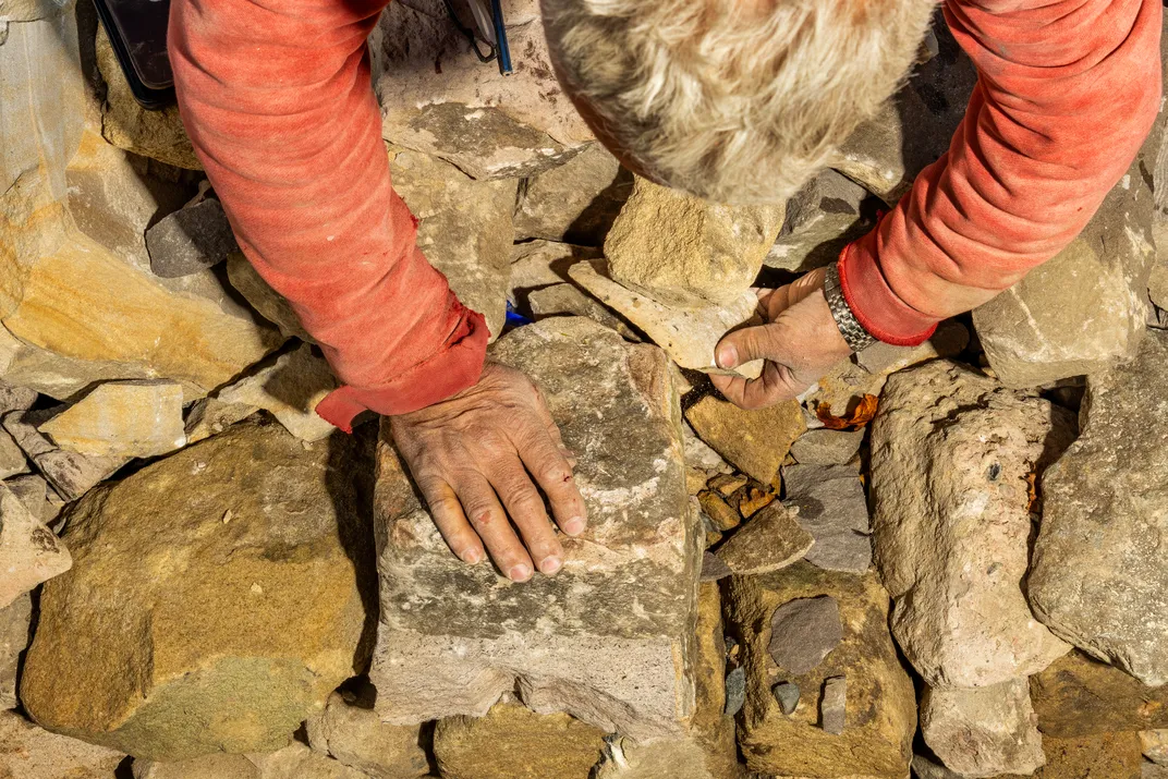 Wilson placing keepsakes between stones