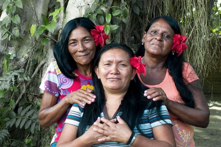 Three Taíno Indian sisters pose during a family pig roast in eastern Cuba, where there’s a small but growing movement to explore the indigenous culture that Columbus encountered in 1492.
