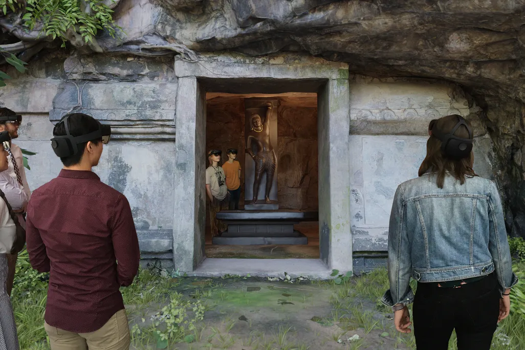 A rendering of the virtual reality experience, which shows a manmade cave cut into the side of a mountain to reveal a Krishna statue