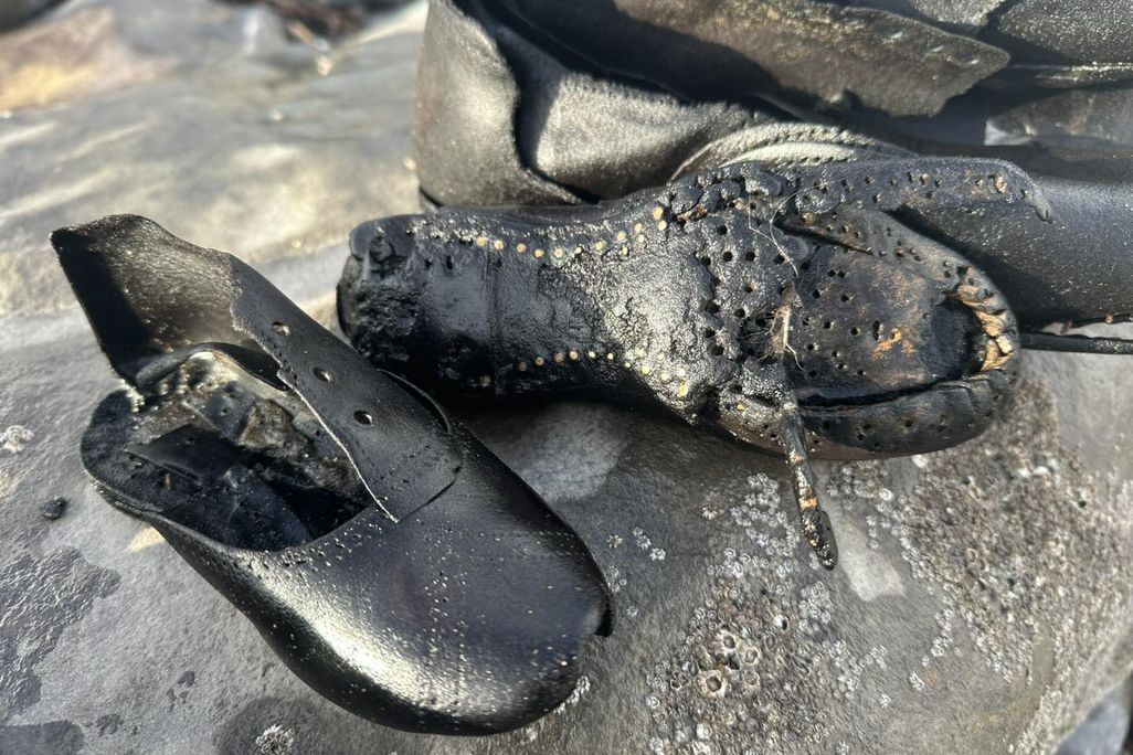 Black leather shoes on sand