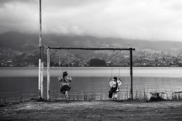 Two young kichwas playing on swing near San Pablo lake thumbnail