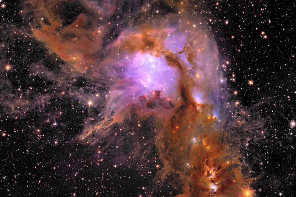 a purple and orange cloud of gas with bright dots of stars all over