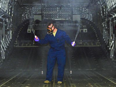 Staff Sergeant Daniel Fink sprays pesticide to rid the cargo hold of a C-17 Globemaster III of any Zika-carrying mosquitoes that may have stowed away.