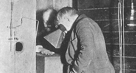 Thomas Edison examines Clarence Dally's, his assistant, hand thru a fluoroscope of his own design.