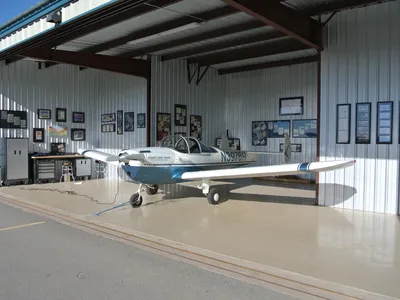 The author’s 1947 Ercoupe 415‑CD at home in its New Mexico hangar, decorated with framed Ercoupe images taken from advertisements and magazine covers.