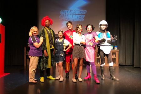 Young Ambassador, Mia Cooper and her supervisor Cathy posing with the cast of the superhero show 