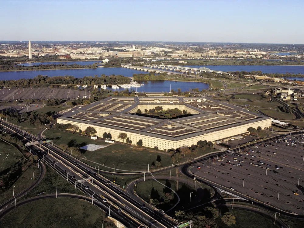 An aerial view of the Pentagon with Washington, D.C, and the Washington Monument in the background