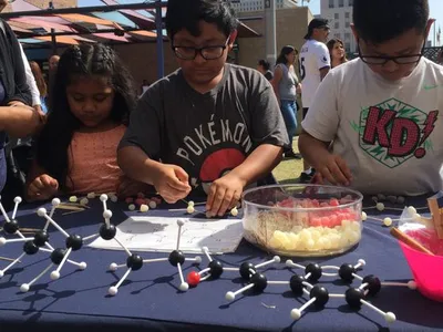 Children participate in a hands-on science activity with the Smithsonian Latino Center for a Dia del Niño festival hosted by LA Plaza de Cultura y Arte in Los Angeles, California.